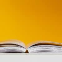 White book in white table near yellow wall