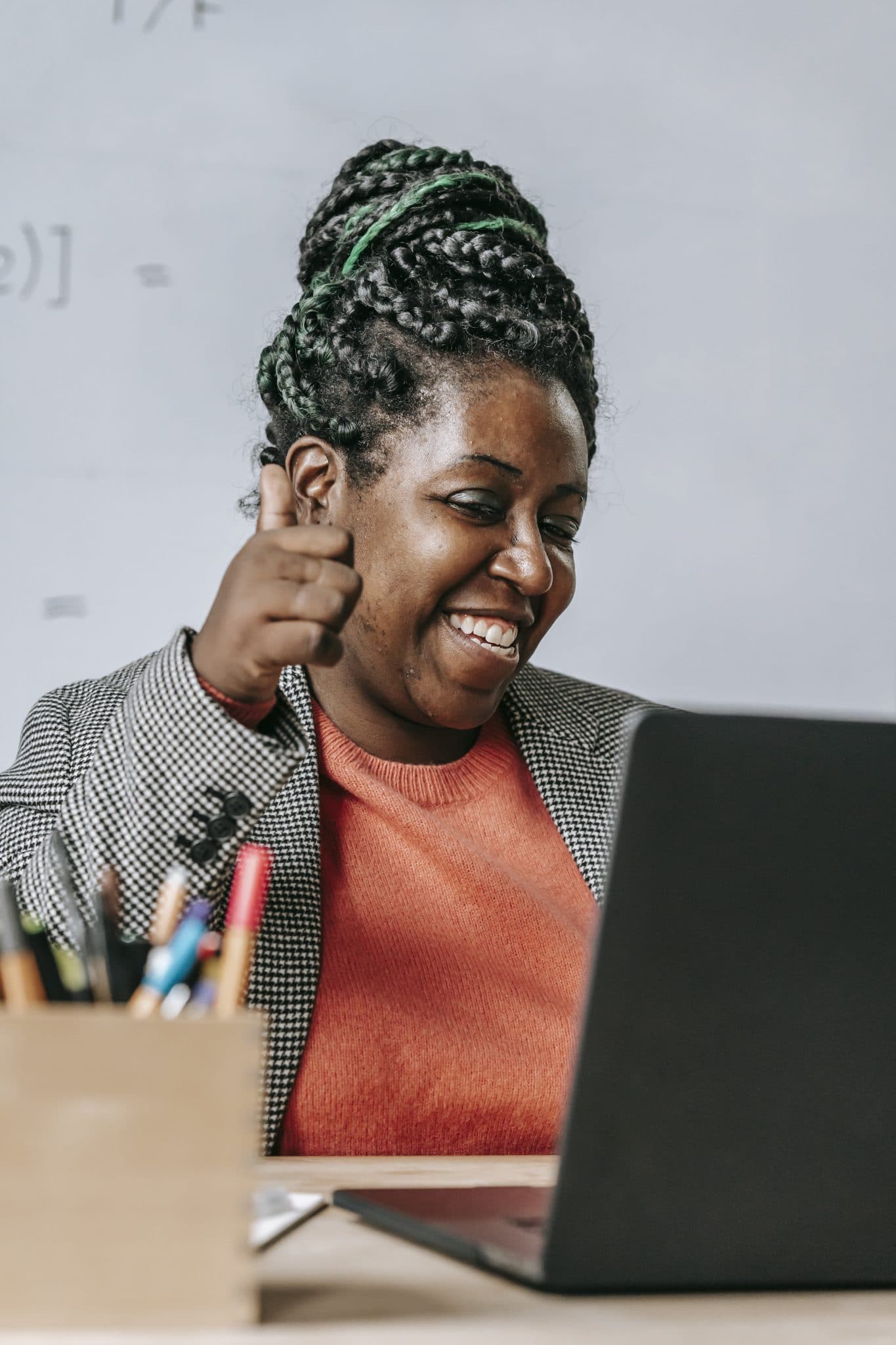 Positive black teacher showing thumb up during online test