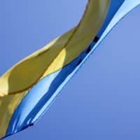 Ukrainian flag waving in wind with clear sky in background